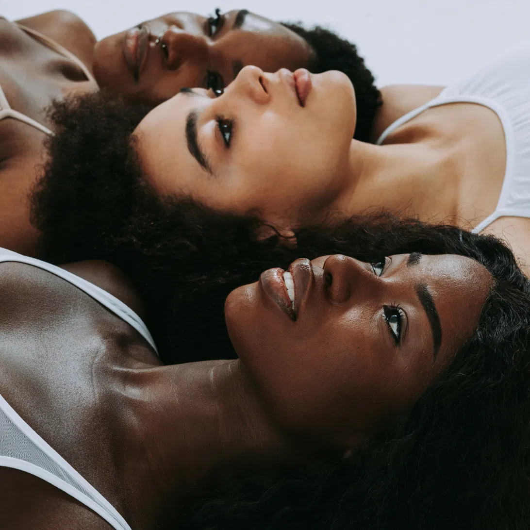 Black women resting together in soft light